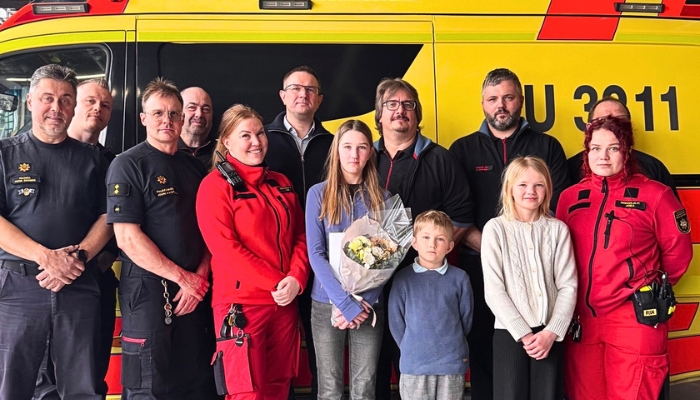 Maryelle Nybergh sisarustensa ja Tammisaaren paloaseman työvuoron kanssa. Taustalla ambulanssi.