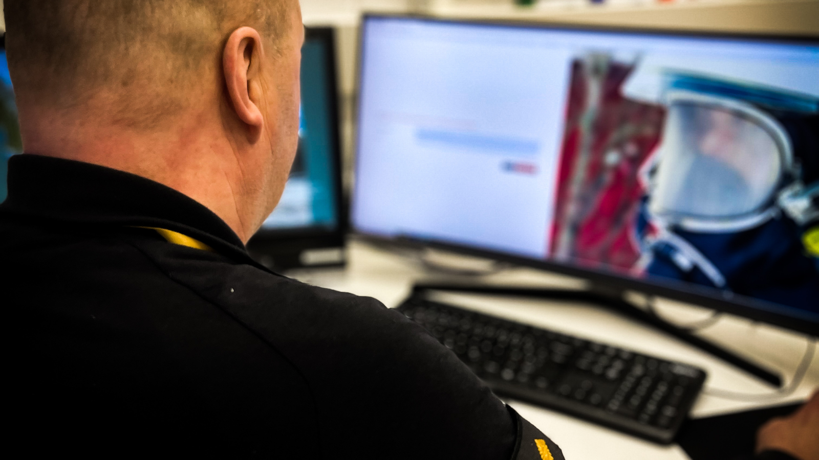 Henkilö katsoo tietokoneen ruutua.
