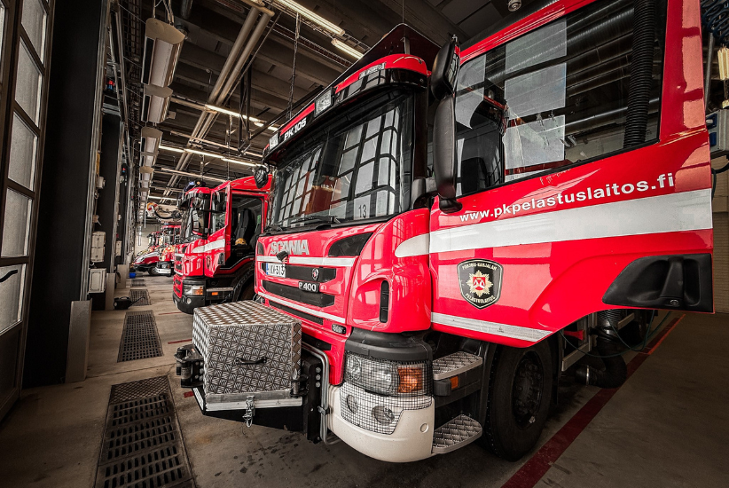 Pelastustoimen hälytysajoneuvoja kalustohallissa.