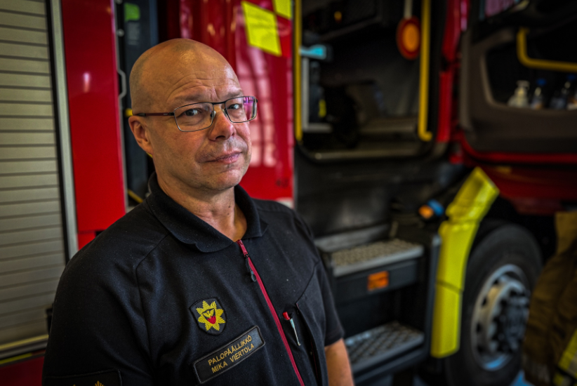 Henkilö seisoo hälytysajoneuvon vieressä