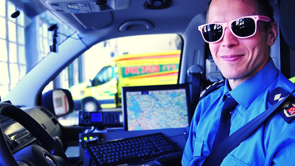 Palopäällikkö aurinkolasit päässä päivystysyksikön kuljettajan penkissä.