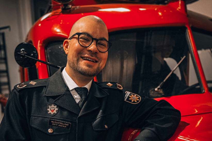 Henkilö nojaa pelastustoimen museoajoneuvoon.