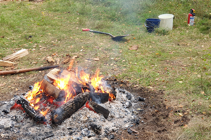 Nuotio, jonka vierellä on sammutusvälineitä: kaksi ämpärillistä vettä sekä käsisammutin.