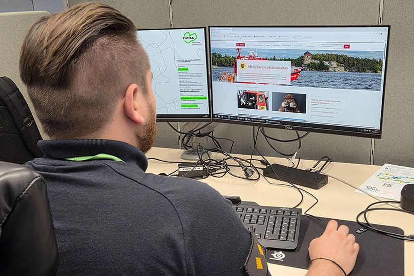 Palomestari Joona takaapäin kuvattuna selaamassa Etelä-Savon pelastuslaitoksen nettisivuja.