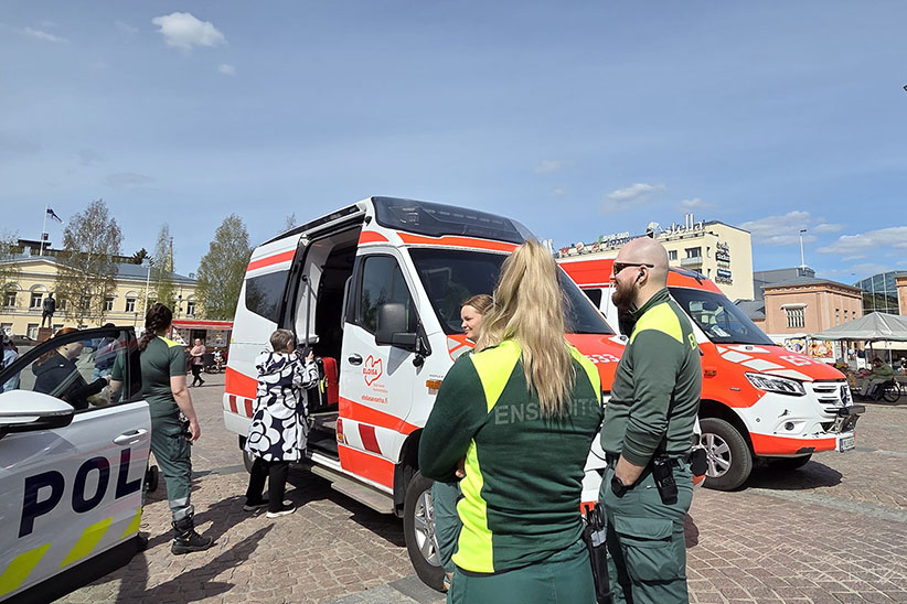 Kuvituskuvassa Eloisan ambulansseja ja ensihoitajia yleisötapahtumassa Mikkelissä. Sivussa näkyy myös poliisiauto.