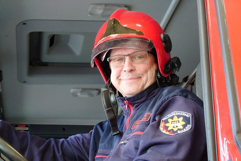 Kari Summanen Sulkavan sopimuspalokunnasta hymyilee kypärä päässä.