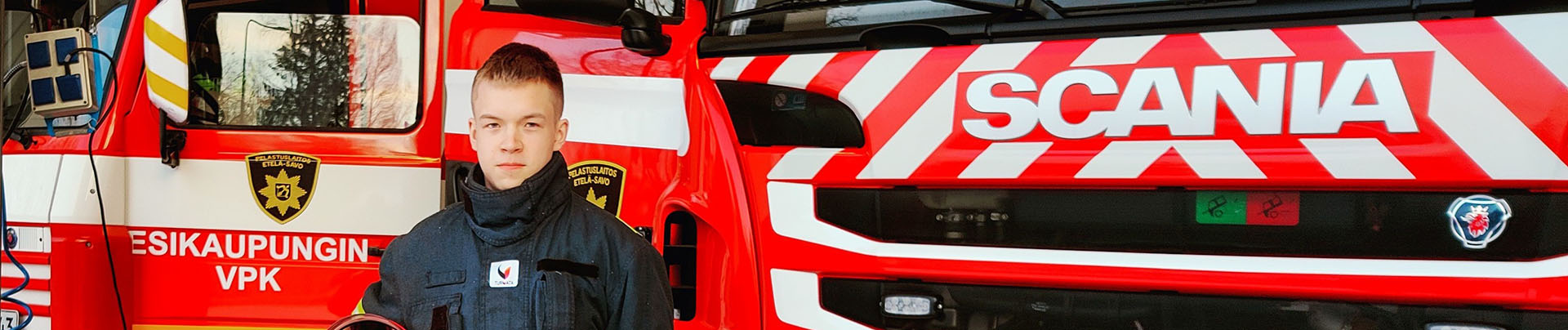 Mikkelin esikaupungin nuori sopimuspalokuntalainen Paavo Mäkelä seisoo paloauton edessä.