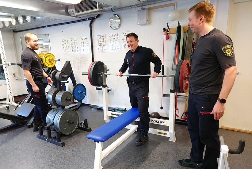 Kuvituskuva: Palomestari Eero ja palomiehet Mikko ja Marko kuntosalilla.