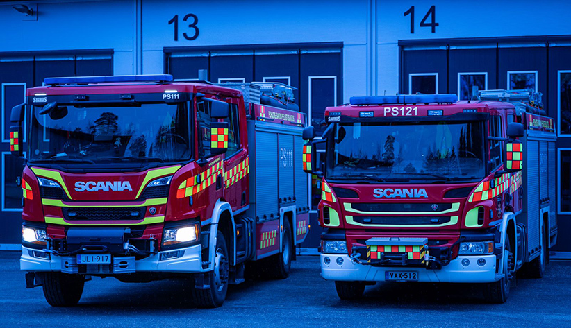 Kuvituskuva: paloautoja paloaseman edessä.