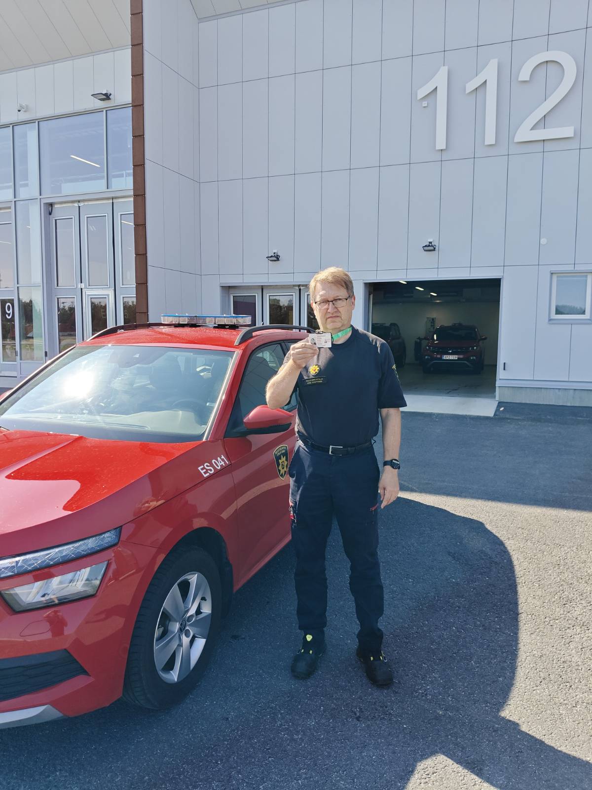 Etelä-Savon pelastuslaitoksen oikea palotarkastaja virka-asussaan, pelastuslaitoksen ajoneuvo ja virkakortti.