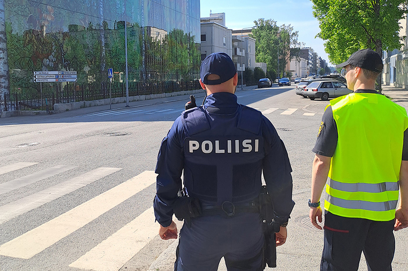 Poliisi ja pelastuslaitoksen edustaja valvomassa suojatietä.