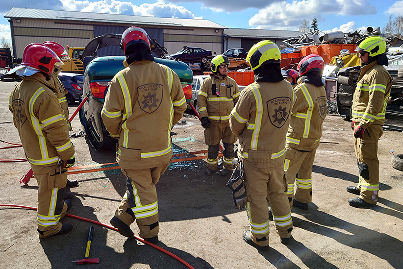 Sopimuspalokuntalaisia tieliikennepelastamisen kurssilla harjoittelemassa pelastamisen tekniikoita romuautojen parissa.