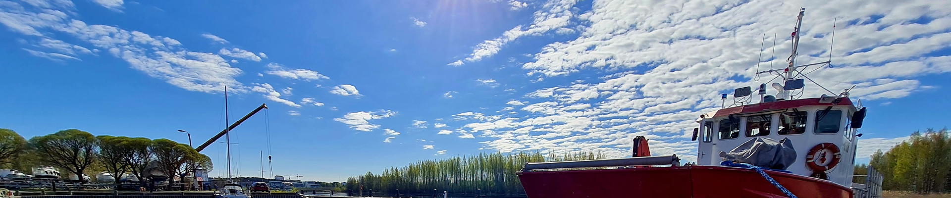 Pelastusvene laiturissa ja sininen, pilvinen taivas.