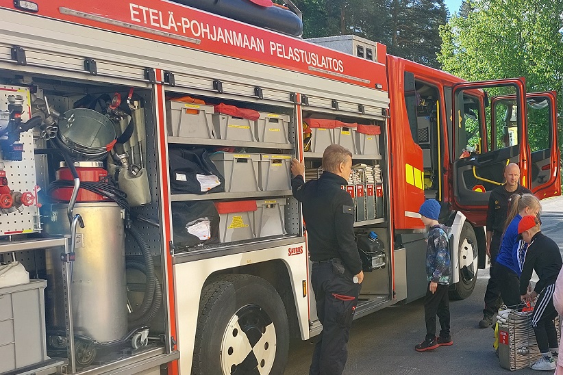 Paloauton edessä kaksi palomiestä.