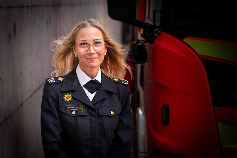 rehtori Sanna Aivio seisoo paloauton edessä virkapuvussa