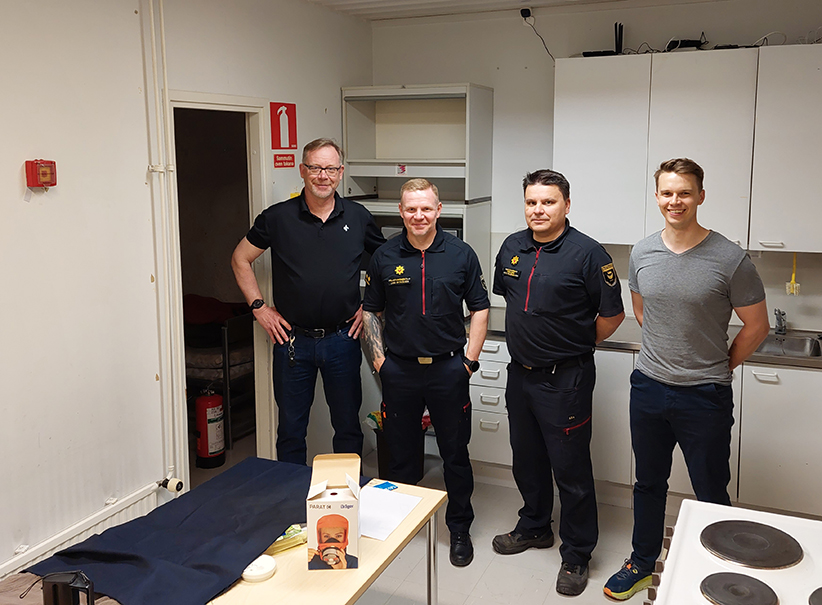Four members of the Helsinki Rescue Department's management team in the escape room.