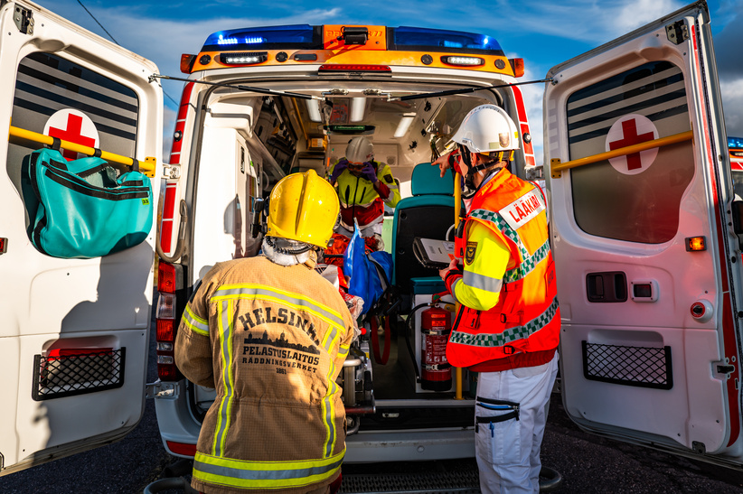 Pelastajat ambulanssin takaovella.