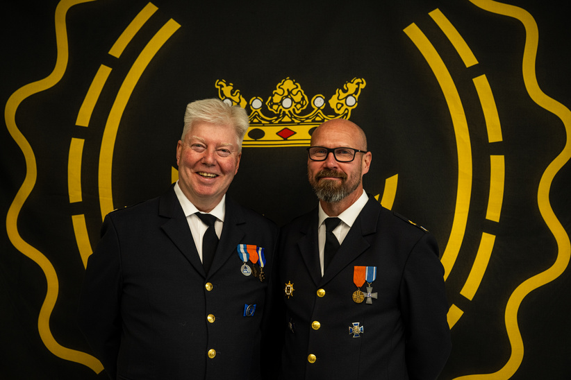 Two men standing in dark festive attire