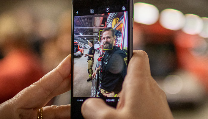 The phone is used to take a picture from smiling firefighter. 