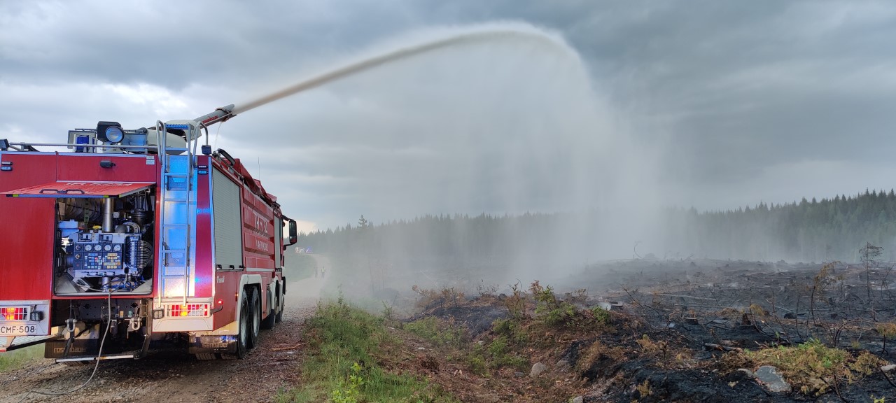 Sammutusauto sammuttaa maastopaloa