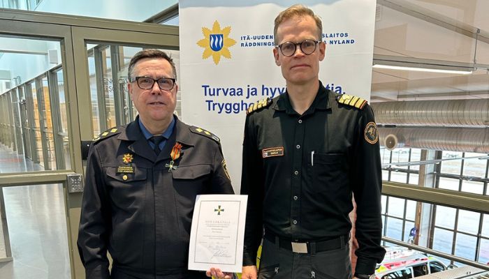 Pelastusjohtaja Peter Johansson ja Suomenlahden merivartioston komentaja, kommodori Mikko Simola pitelevät todistusta ansiorististä.