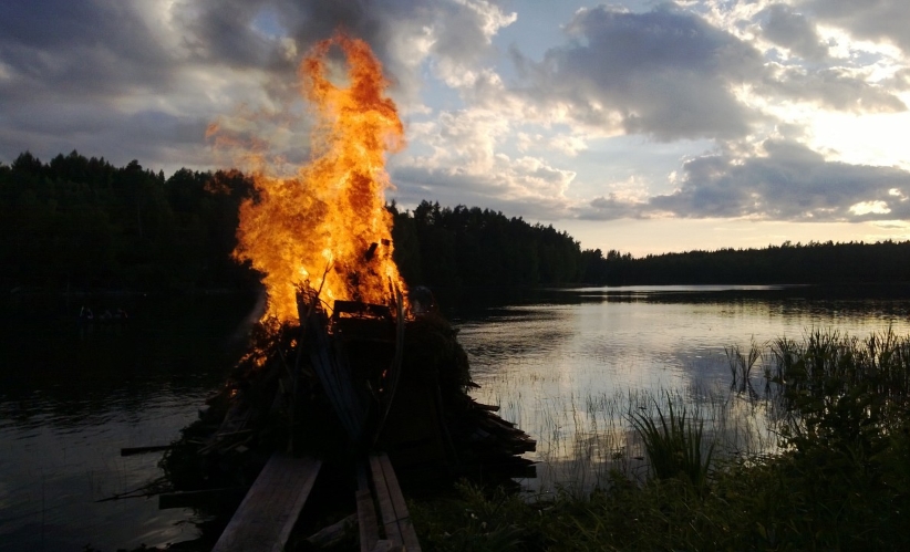 Palava kokko iltahämärässä järven rannassa.