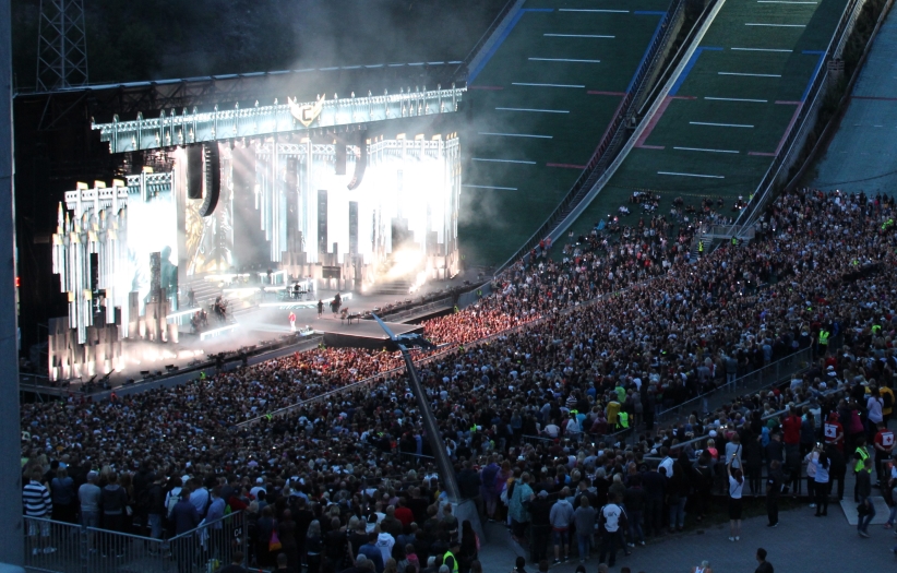 Konserrtilava ja yleisöä pimeässä.