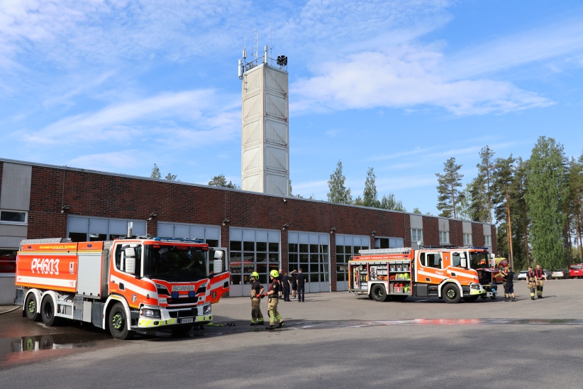 Paloautoja ja pelastajia paloaseman pihalla.