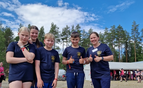 Iloisia nuoria siniset palokuntapaidat päällä ulkona.