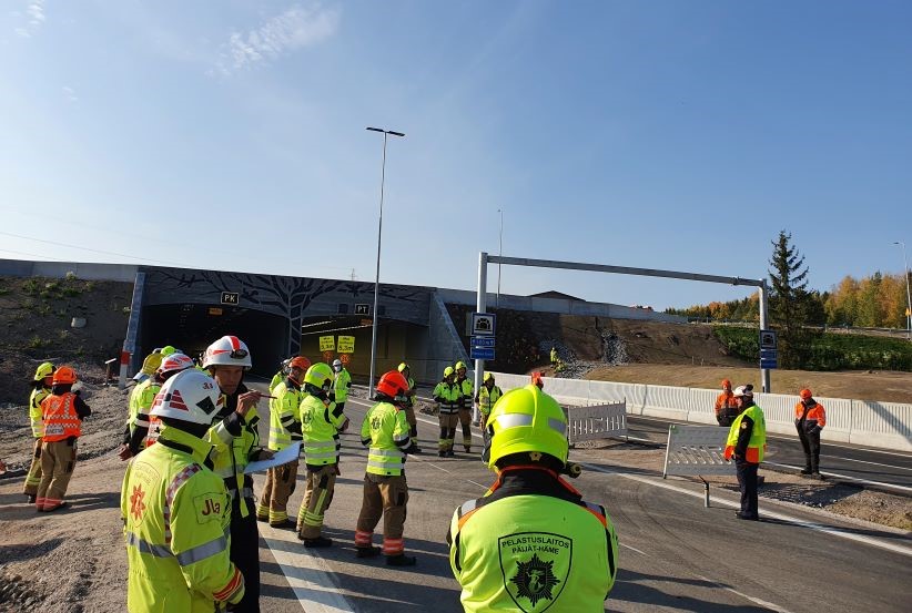 Pelastusalan virka-asuisia henkilöitä maantietunnelin edessä.