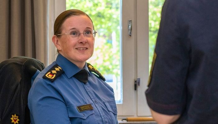  Pelastus- ja ensihoitopalveluiden työntekijä hymyilee virka-asussaan. 