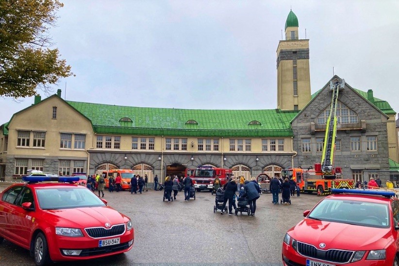 Tampereen Keskuspaloaseman pihalla pelastuslaitoksen ajoneuvokalustoa ja ihmisiä.