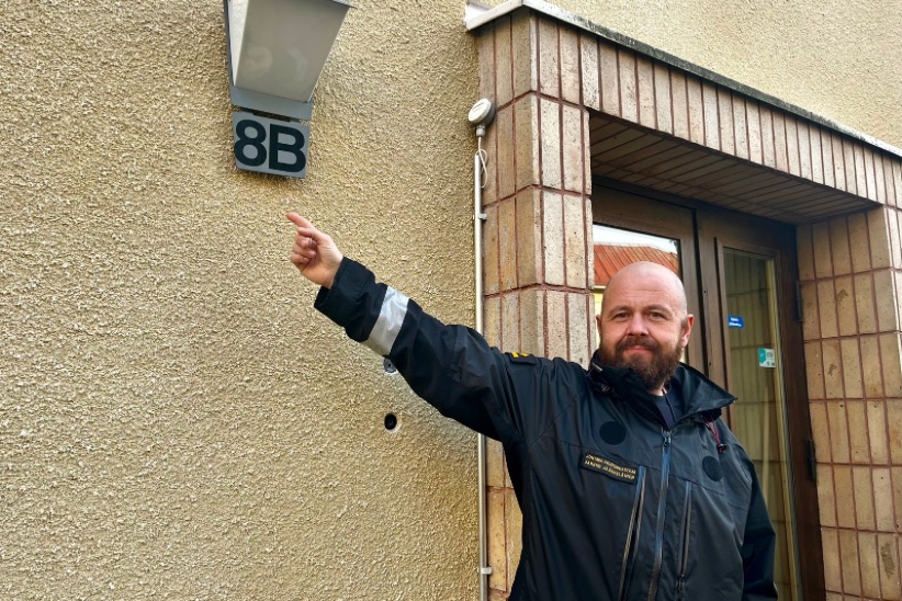 Johtava palotarkastaja Jarkko Jääskeläinen osoittaa talon seinässä olevaa numerointia.