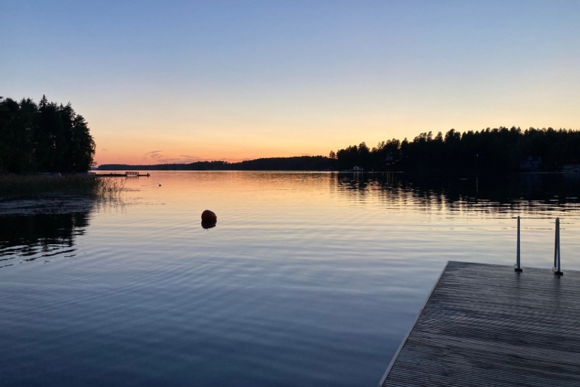 Syksyinen auringonlasku järvenrannalta kuvattuna.