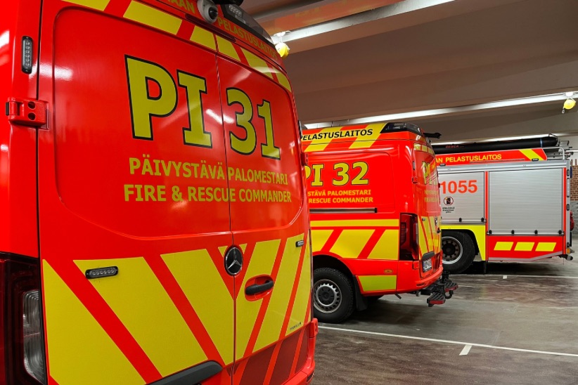 Päivystävien palomestarien ajoneuvoja rivissä keskuspaloaseman kalustohallissa.
