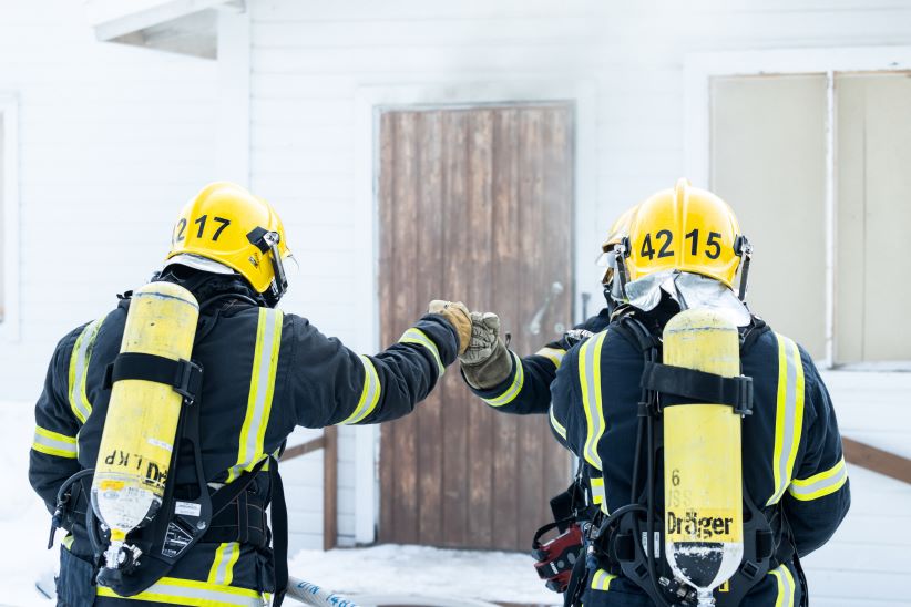  Kolme pelastajaa talonpolttoharjoituksessa. 