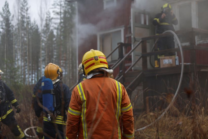  Ruiskumestari seisoo palavan talon edessä. 