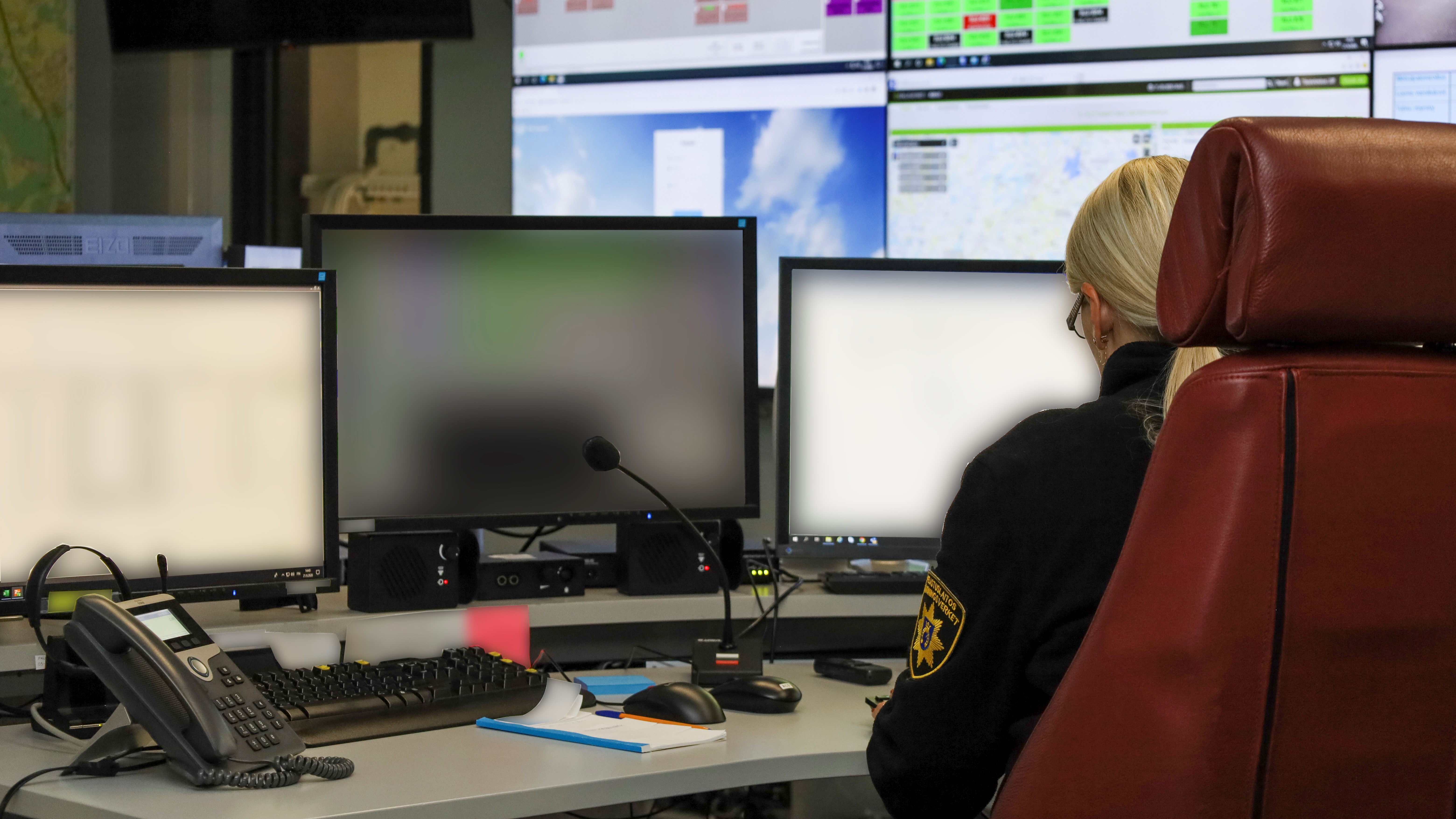  En person som sitter framför flera datorskärmar i räddningsverkets lägecentral. 
