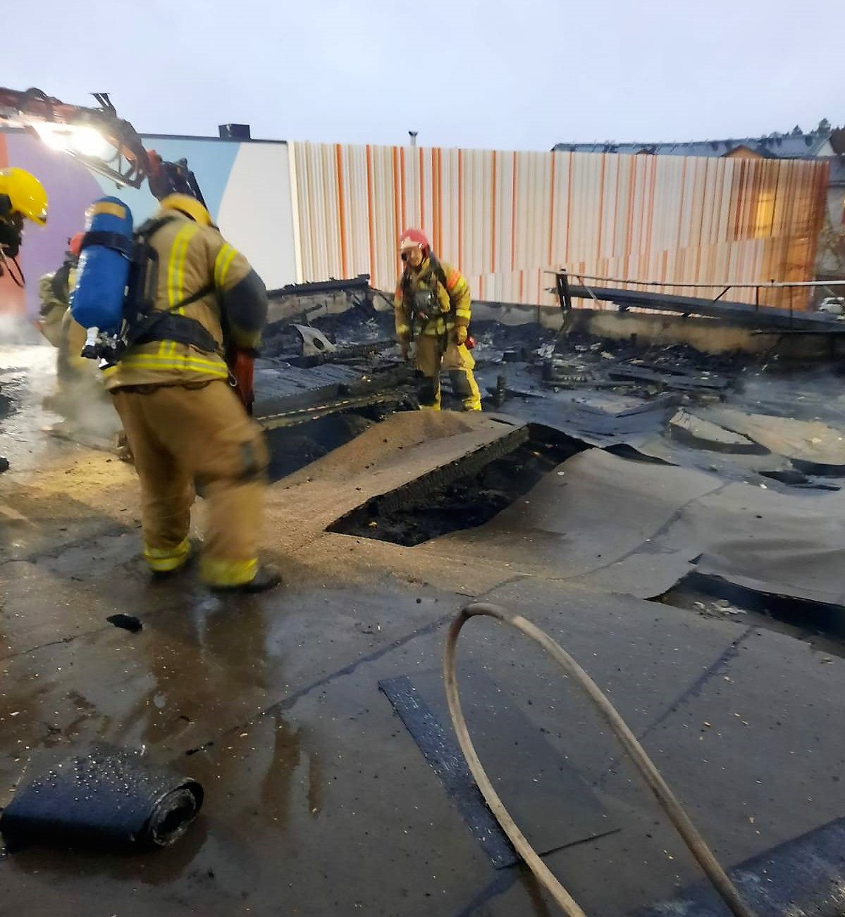 Palomiehet sammuttavat tulipaloa kerrostalon katolla.