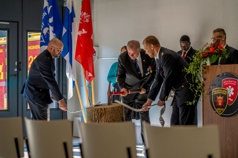 Perinteinen vihkiäistraditio, jossa paloletku katkaistaan kirveellä. Kuva: Kristian Eloluoto.