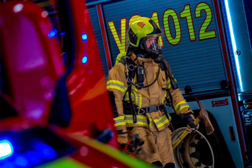 Pelastaja kahden paloauton välissä.