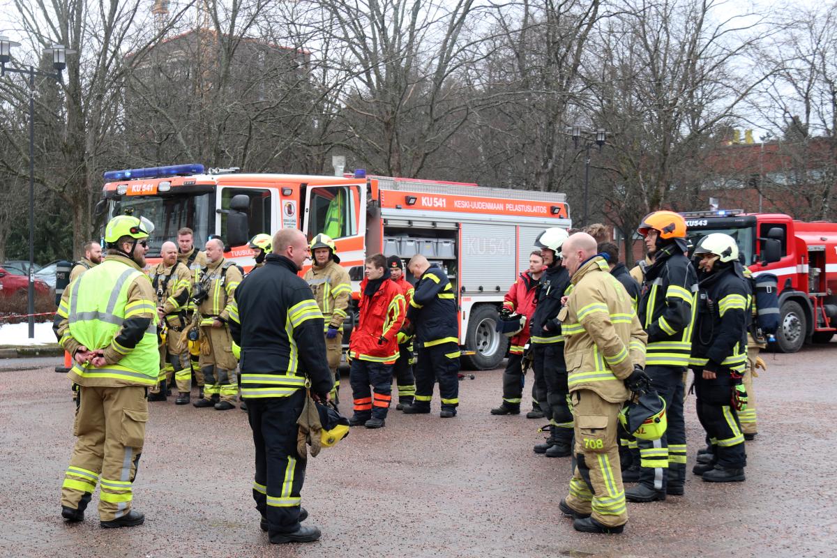 Sopimuspalokuntalaisia seisoo paloauton edessä.